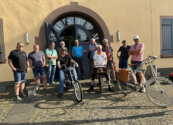 Aktive des ADFC Mainz-Bingen vor dem Rheinhessischen Fahrradmuseum in Gaul-Algesheim beim Testen historischer Räder